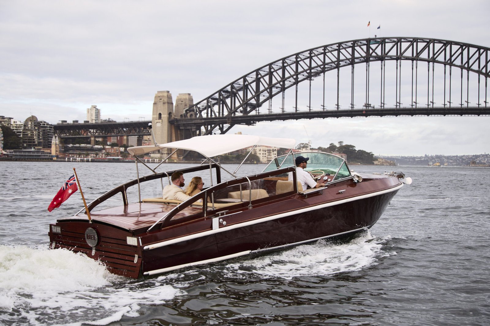 Luxury boat MV Bel cruising past Sydney Harbour Bridge