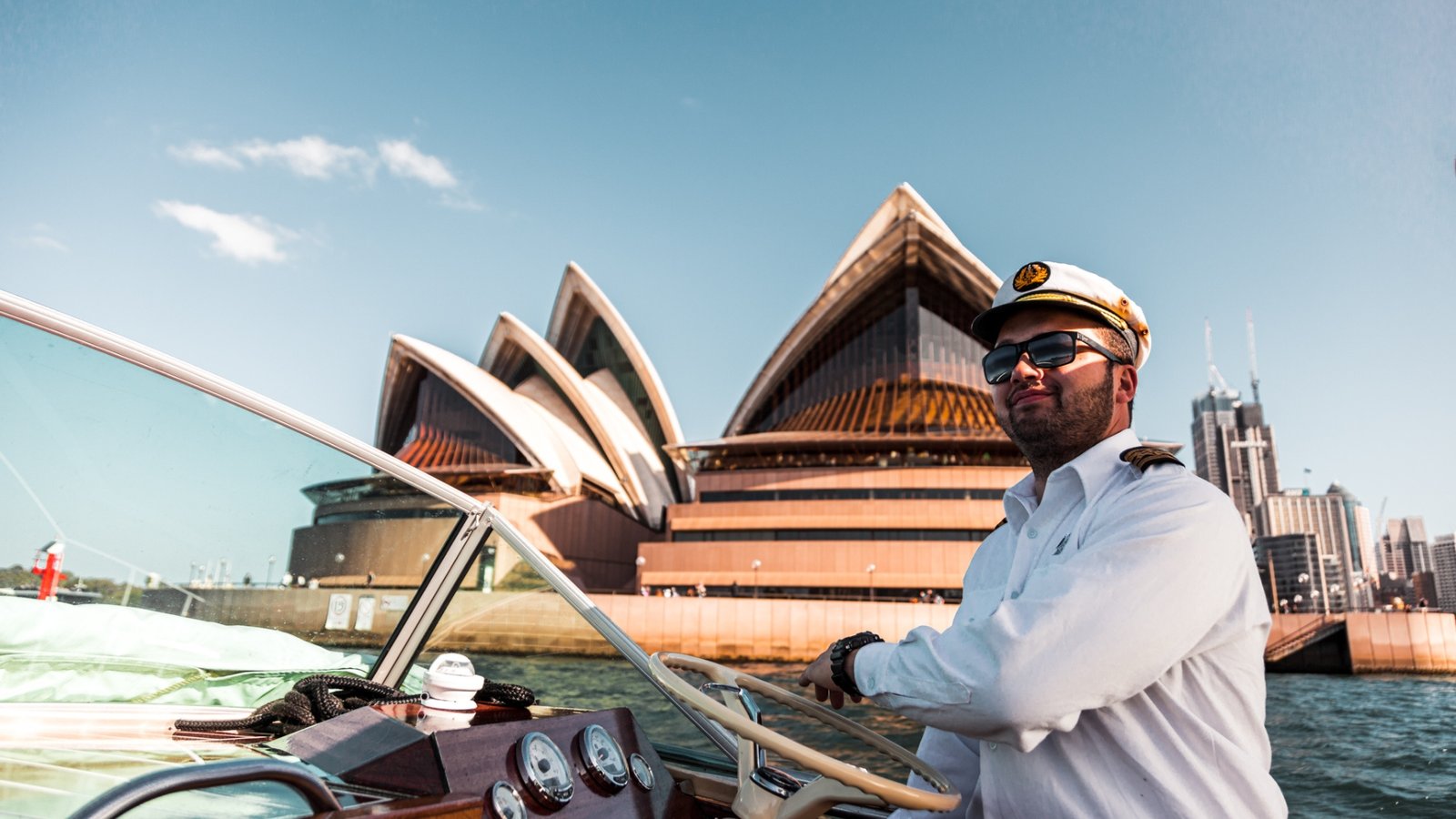 Captain steering MV Bel with Sydney Opera House in the background